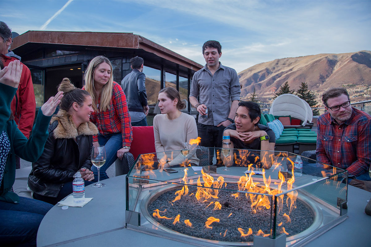 people sitting around an outdoor fire pit at CBC Aspen