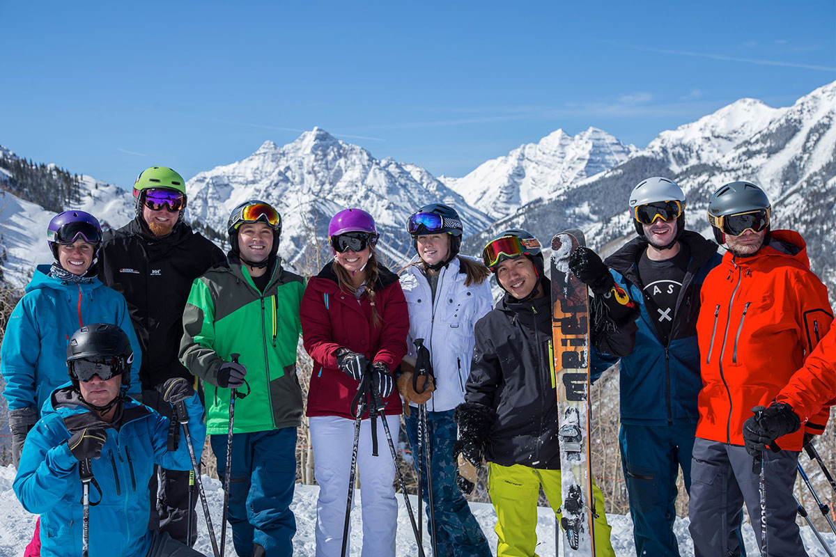 group of skiers standing with mountain in background at CBC Aspen