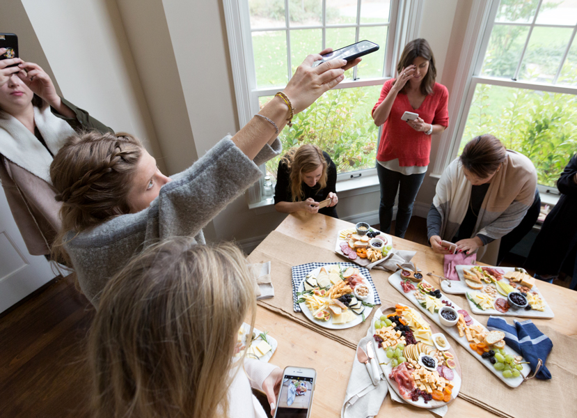 influencers taking pictures of cheese platters at Hosting House