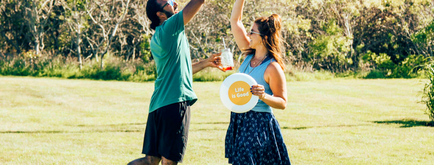 Man and woman holding frisbee giving a high five