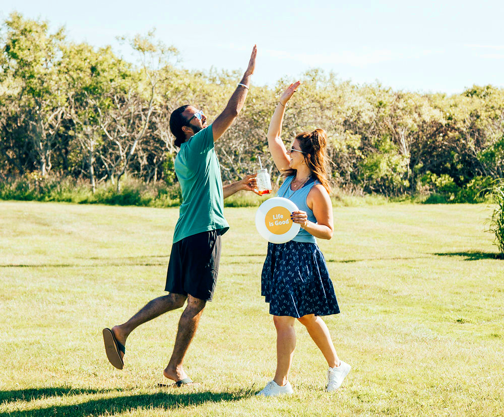 Man and woman holding frisbee giving a high five