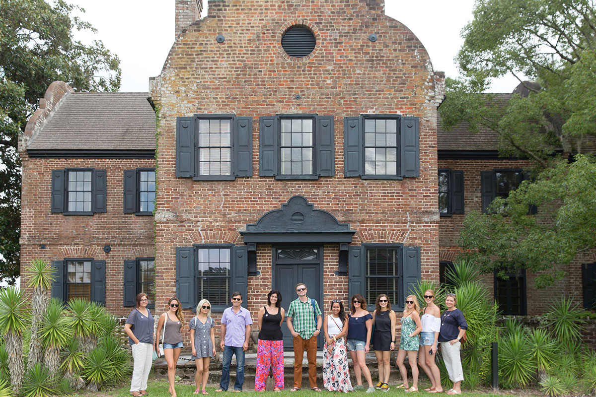 people standing in front of a brick house at the CBC Charleston experience