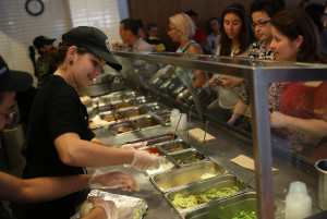 MIAMI, FL - APRIL 27: Chipotle restaurant workers fill orders for customers on the day that the company announced it will only use non-GMO ingredients in its food on April 27, 2015 in Miami, Florida. The company announced, that the Denver-based chain would not use the GMO's, which is an organism whose genome has been altered via genetic engineering in the food served at Chipotle Mexican Grills. (Photo by Joe Raedle/Getty Images)
