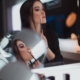 girl applies makeup in front of mirror