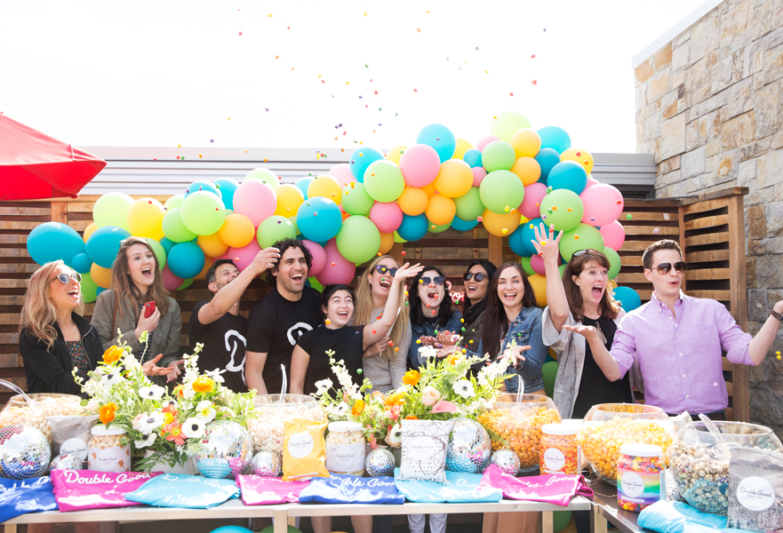 Influencers and editors throwing confetti in front of a popcorn bar at Culinary House