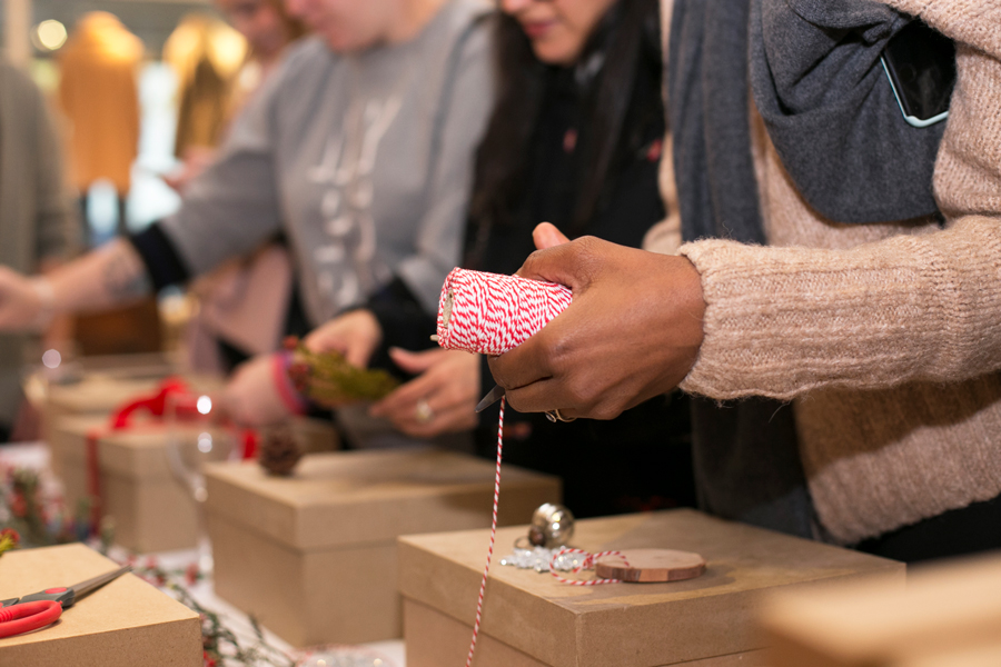 person holding string to wrap a holiday gift