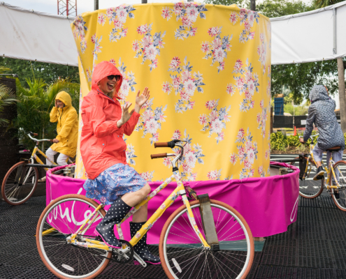 Women in raincoats riding bike carousel