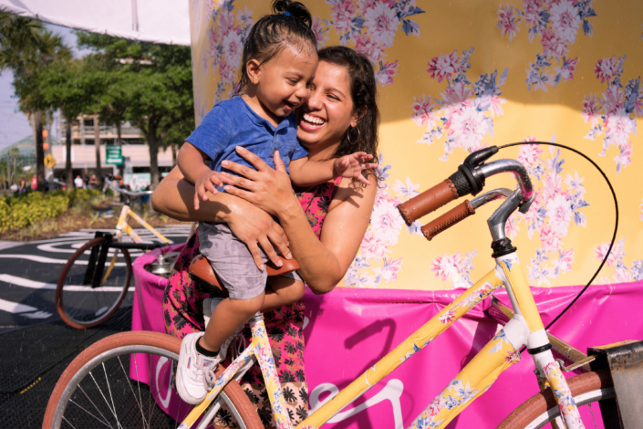 Mother and daughter laughing on bike carousel