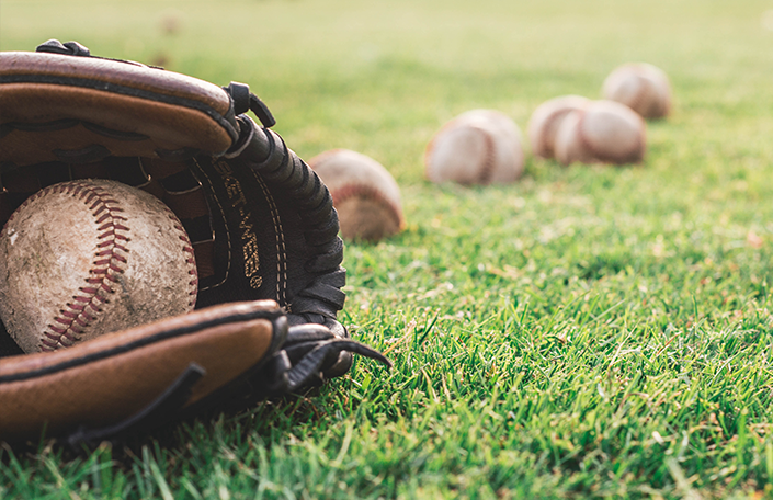 Baseball mitt and baseballs on grass