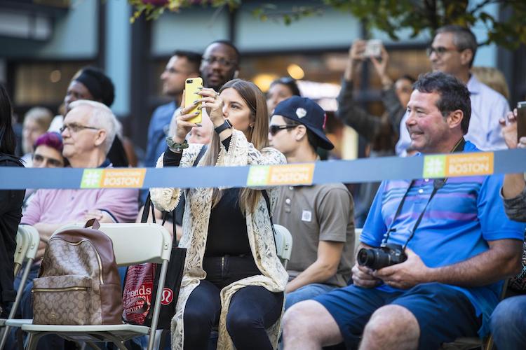 An audience member takes a video of the fashion show