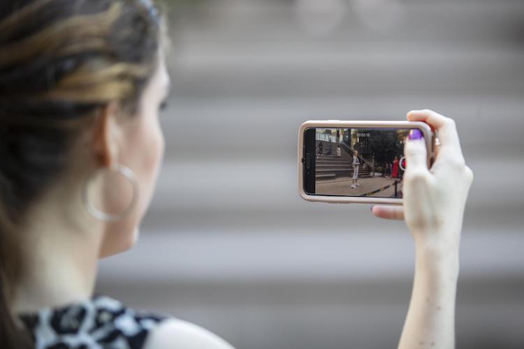 An audience member takes a video of the fashion show