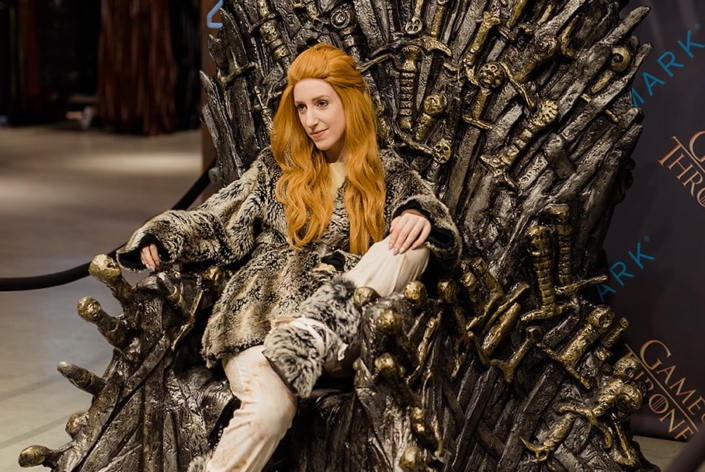 Fans in costume pose on the Iron Throne at Primark