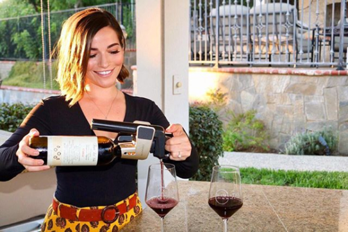Influencer pouring wine using a Coravin outside